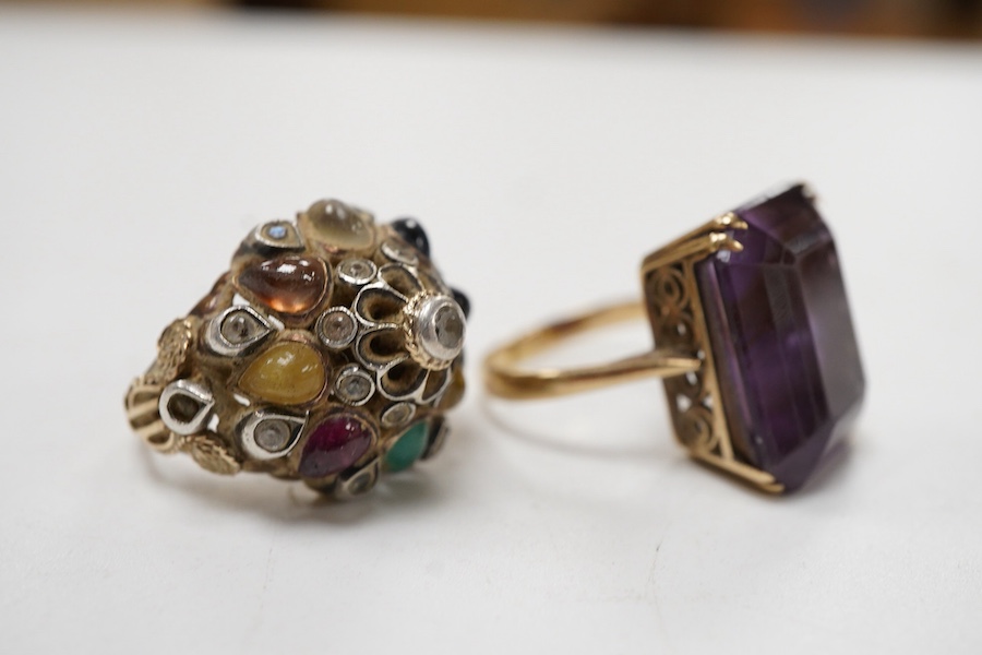 A yellow metal and single stone emerald cut amethyst set dress ring, size Nm together with an Indian? yellow metal and multi gem set ring.
